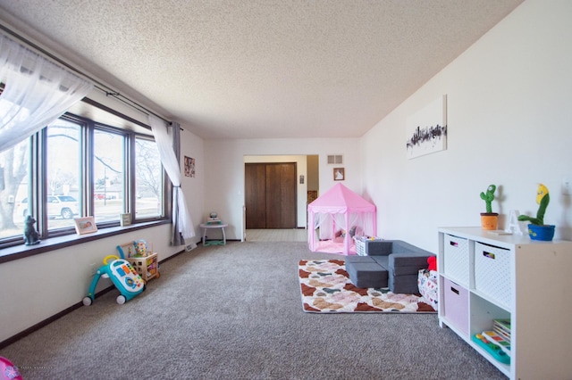 game room featuring baseboards, visible vents, carpet floors, and a textured ceiling