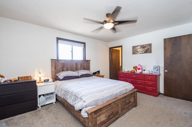 bedroom featuring light colored carpet, a textured ceiling, and a ceiling fan