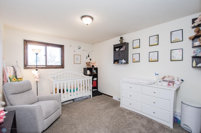 carpeted bedroom featuring a crib and a textured ceiling