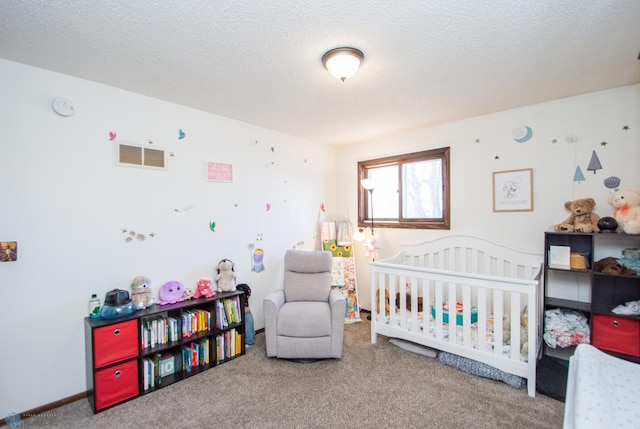 bedroom with a nursery area, carpet, visible vents, and a textured ceiling