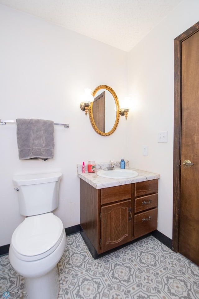 bathroom featuring vanity, toilet, and baseboards