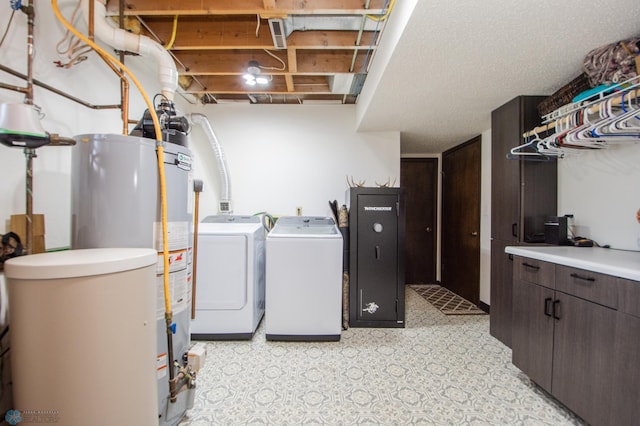 clothes washing area with cabinet space, light floors, and independent washer and dryer