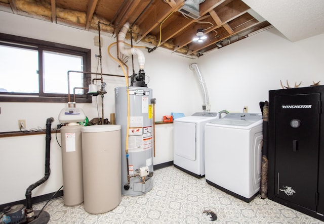 laundry room featuring washing machine and clothes dryer, baseboards, gas water heater, light floors, and laundry area