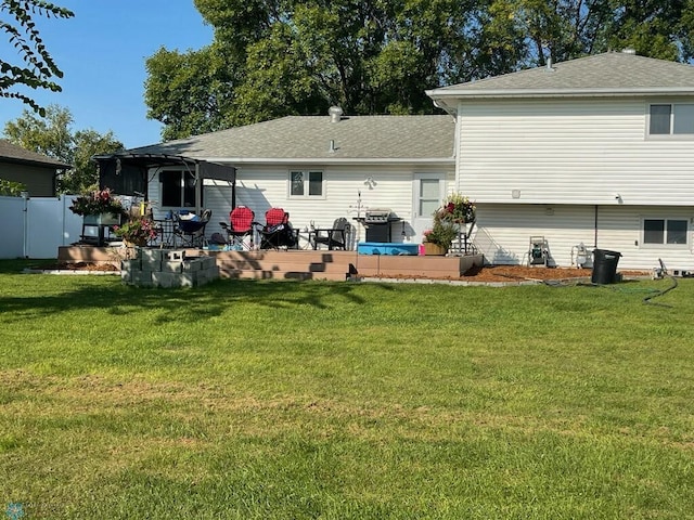 back of house featuring a lawn, a pergola, roof with shingles, and fence