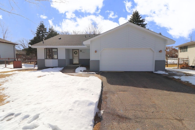 ranch-style home with brick siding, an attached garage, driveway, and fence