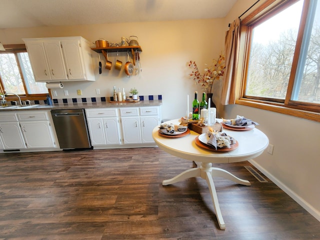 kitchen with a sink, dark wood finished floors, white cabinetry, baseboards, and dishwasher