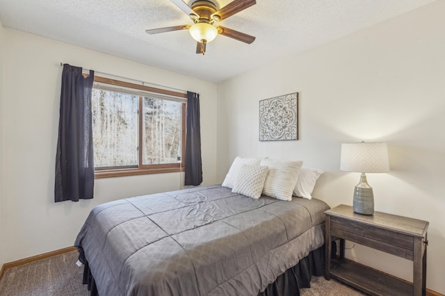 carpeted bedroom featuring ceiling fan, a textured ceiling, and baseboards