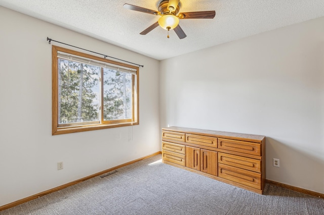 unfurnished bedroom featuring carpet flooring, baseboards, visible vents, and a textured ceiling