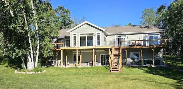 rear view of house featuring stairway, a lawn, a deck, and a patio area