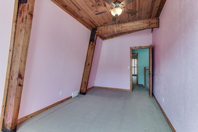 carpeted empty room featuring wooden ceiling, a ceiling fan, baseboards, and vaulted ceiling