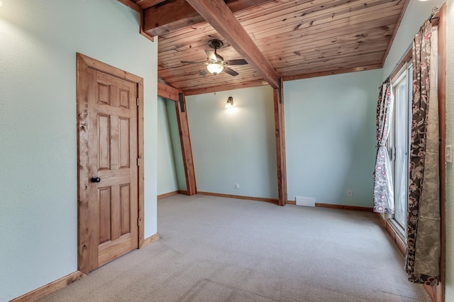 carpeted empty room with visible vents, wood ceiling, baseboards, and a ceiling fan