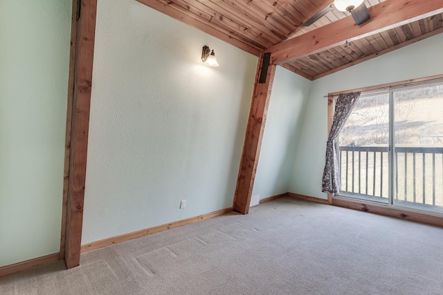 carpeted empty room featuring baseboards, wood ceiling, vaulted ceiling with beams, and a textured wall