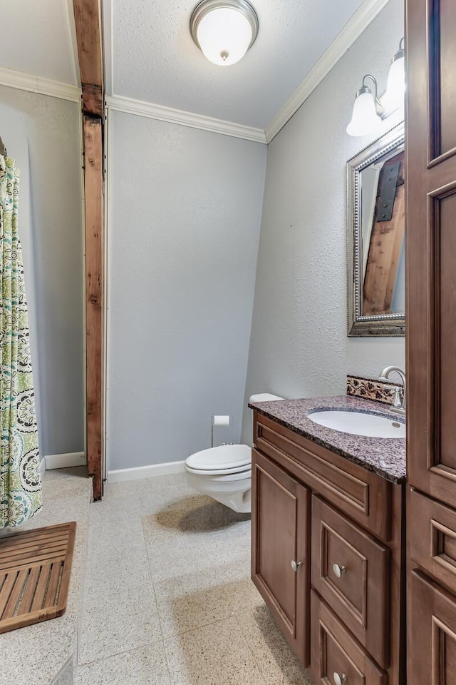 bathroom featuring baseboards, toilet, vanity, and crown molding