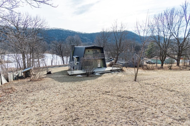 exterior space with a gambrel roof and a deck with mountain view