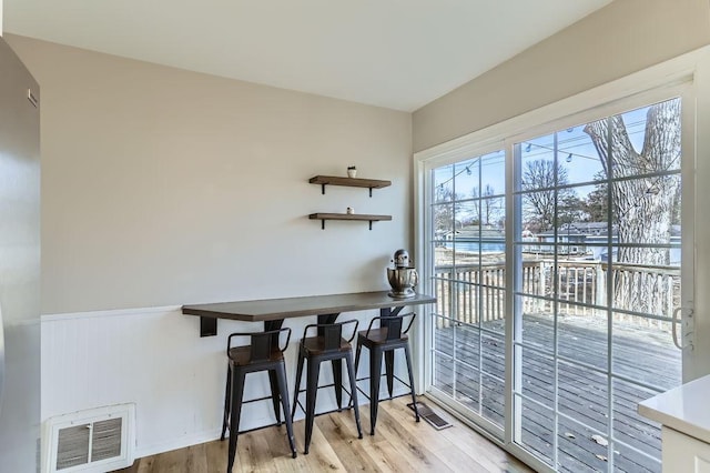 dining space with visible vents and wood finished floors