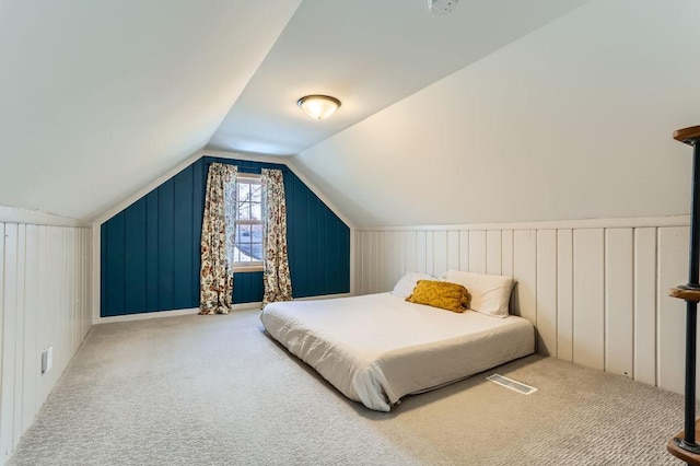 carpeted bedroom with vaulted ceiling and visible vents