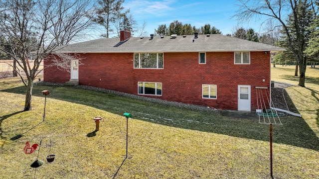 view of side of home featuring brick siding, a chimney, a yard, and roof with shingles