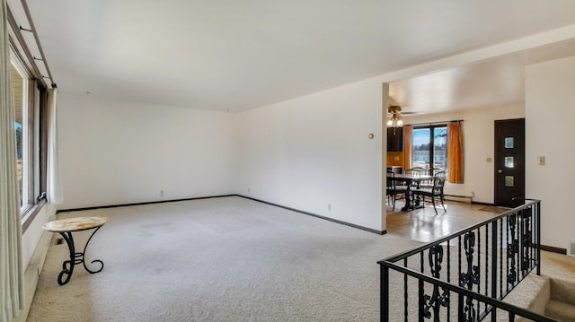 carpeted spare room featuring baseboards and baseboard heating