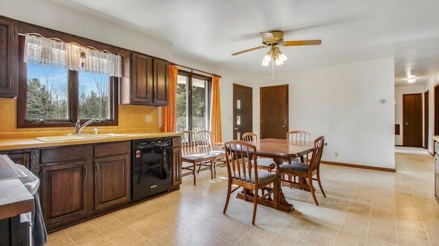 kitchen with baseboards, dishwasher, light countertops, stove, and a sink