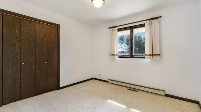 unfurnished bedroom with a baseboard radiator, baseboards, a closet, and light carpet