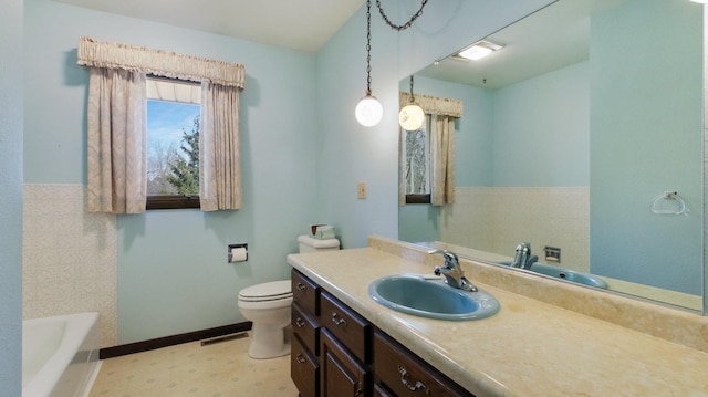 bathroom featuring vanity, a tub to relax in, visible vents, baseboards, and toilet