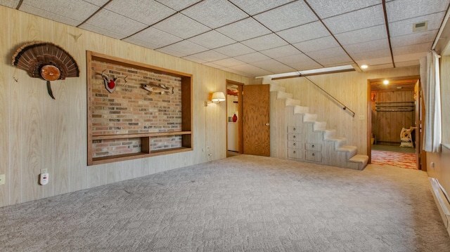 interior space featuring wooden walls, stairway, a paneled ceiling, and carpet floors