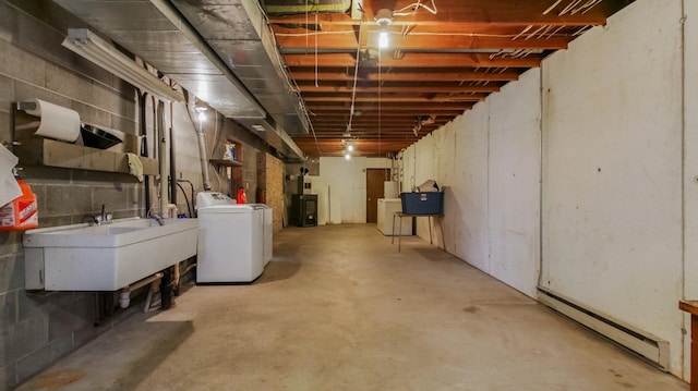 unfinished below grade area featuring a sink, washer / clothes dryer, and baseboard heating