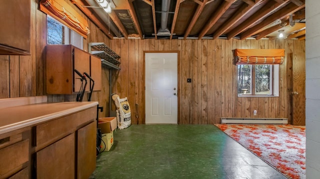 basement featuring tile patterned floors, wooden walls, and baseboard heating