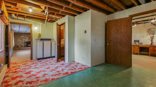 unfinished basement featuring tile patterned floors and a fireplace