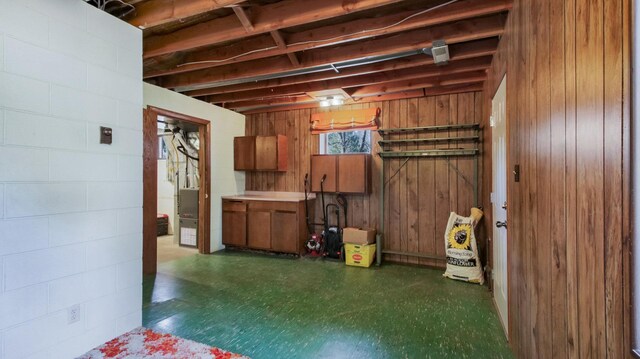 below grade area featuring tile patterned floors and wooden walls