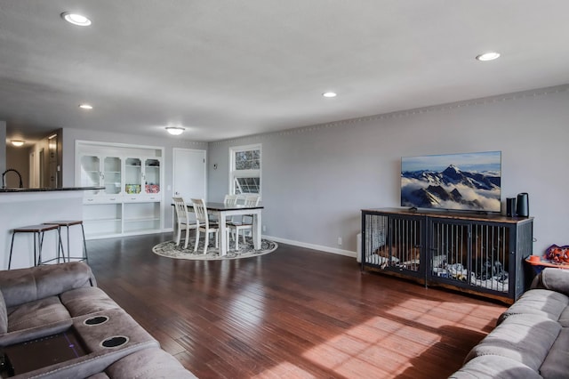 living area featuring hardwood / wood-style floors, built in shelves, recessed lighting, and baseboards