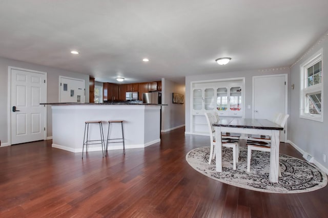 unfurnished dining area featuring recessed lighting, baseboards, and dark wood-style flooring