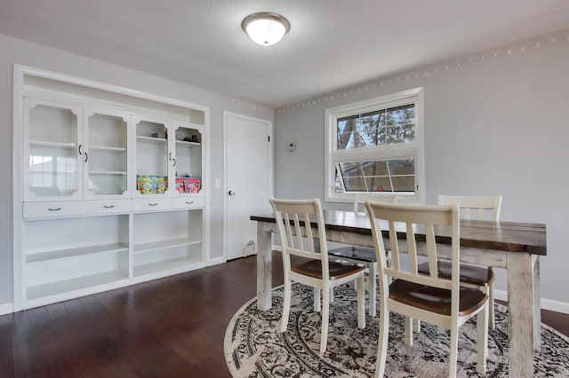 dining room featuring baseboards and dark wood-style flooring