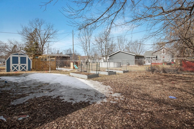 view of yard featuring an outdoor structure, a storage shed, a vegetable garden, and fence