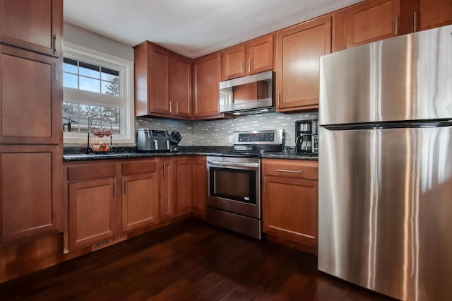 kitchen featuring decorative backsplash, appliances with stainless steel finishes, dark wood finished floors, and brown cabinetry