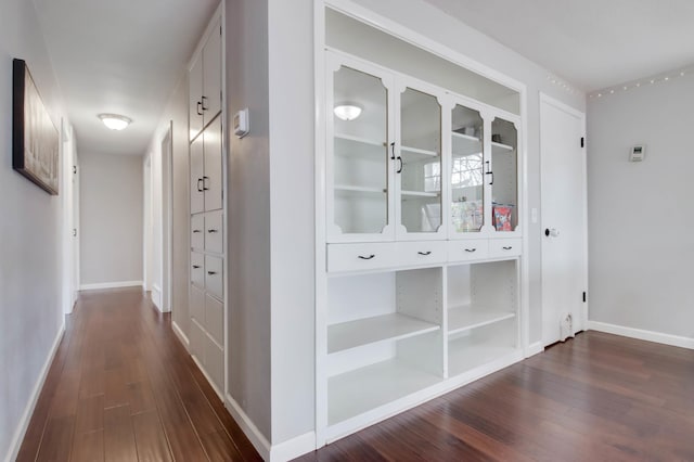 hall featuring dark wood-style floors and baseboards