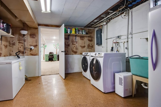 clothes washing area with washer and clothes dryer, laundry area, electric panel, and a sink