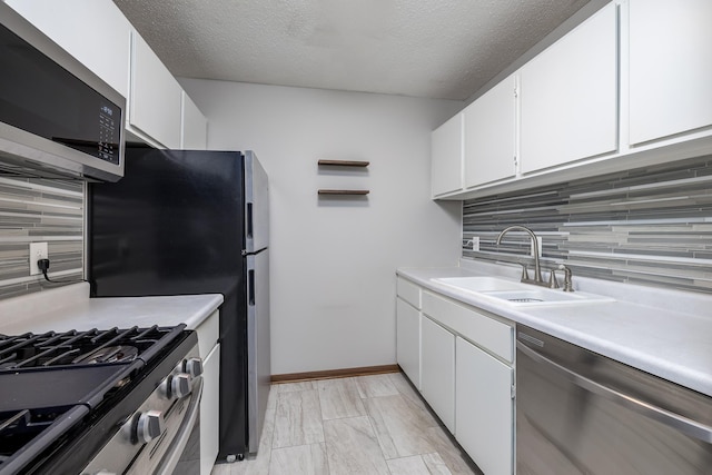 kitchen with tasteful backsplash, stainless steel appliances, light countertops, and a sink