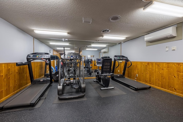 exercise room with wooden walls, wainscoting, a textured ceiling, and an AC wall unit