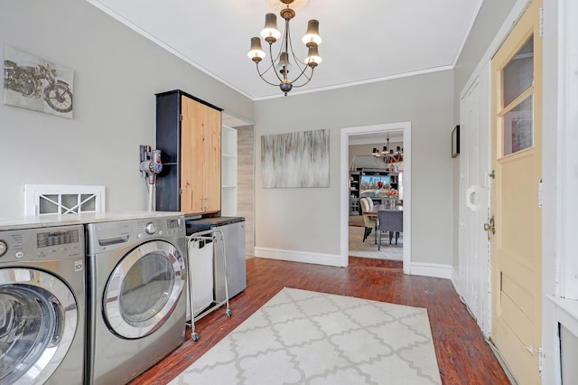 washroom featuring a notable chandelier, ornamental molding, washer and clothes dryer, dark wood-style floors, and cabinet space