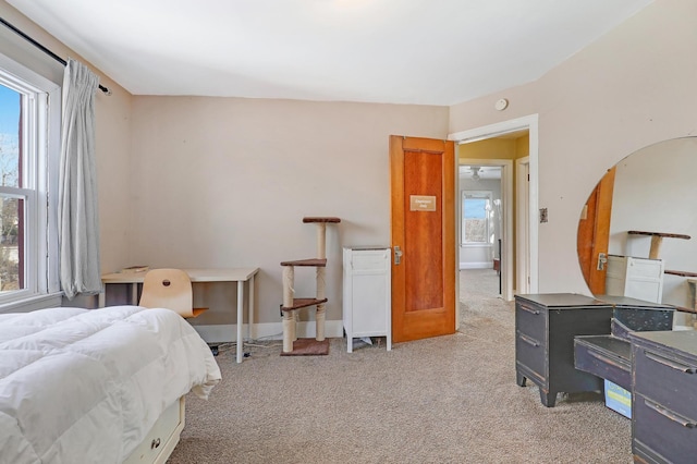 carpeted bedroom featuring baseboards and multiple windows