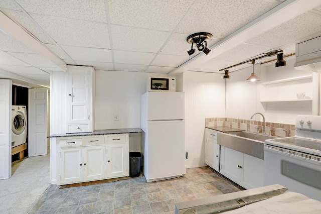 kitchen with washer / dryer, white appliances, white cabinetry, a paneled ceiling, and a sink