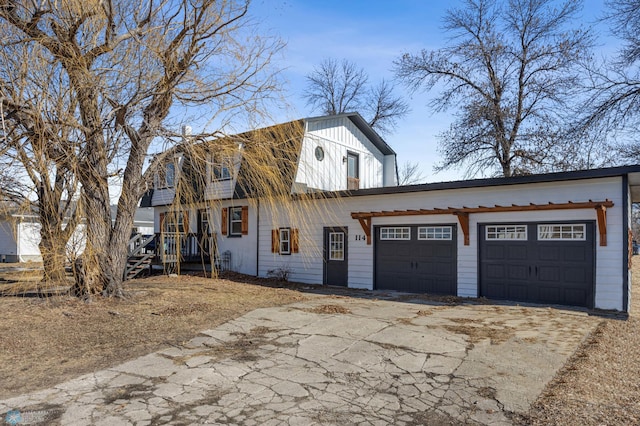 view of side of property featuring aphalt driveway, board and batten siding, and an attached garage