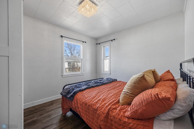 bedroom featuring crown molding, wood finished floors, and baseboards