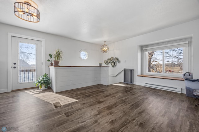 foyer featuring a notable chandelier, baseboard heating, and wood finished floors