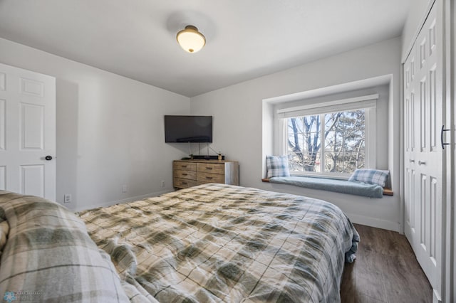 bedroom featuring a closet, baseboards, and wood finished floors