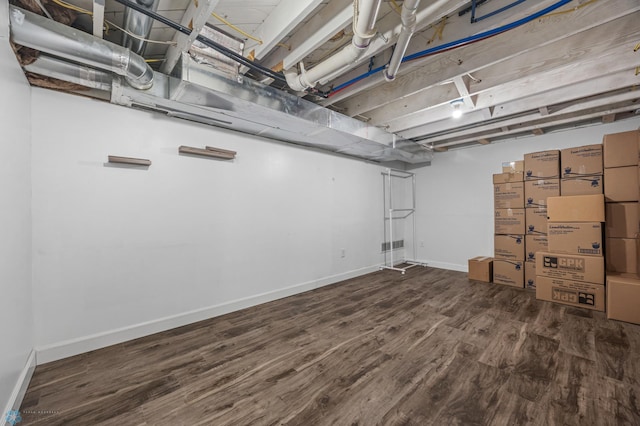 unfinished basement featuring baseboards and wood finished floors