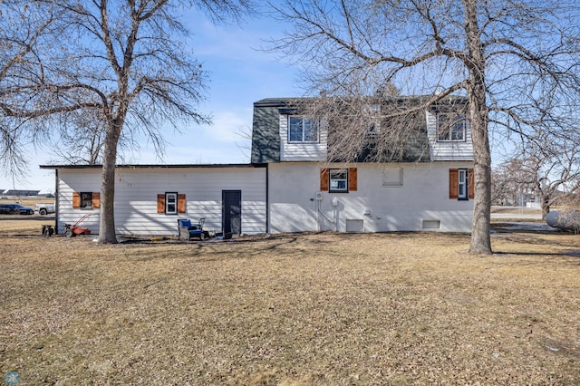 rear view of property with crawl space and a lawn