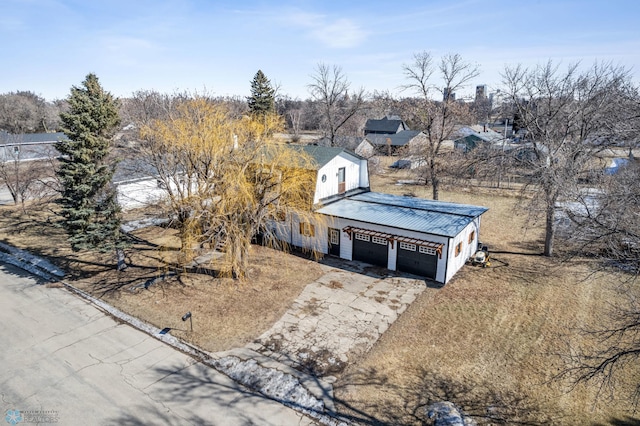 view of front of house featuring metal roof, an attached garage, and driveway