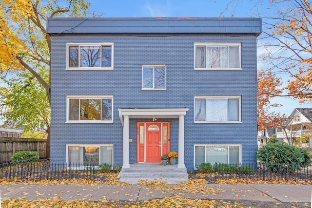 view of front facade with a fenced front yard and brick siding